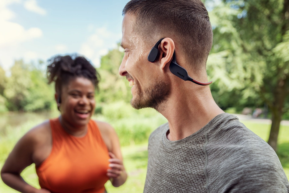 Frau und Mann beim Outdoor-Training mit Philips Sports Headphones